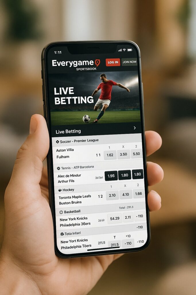 Person holding a smartphone displaying the Everygame Mobile Experience for live betting on various sports like soccer and tennis offering a seamless betting interface.